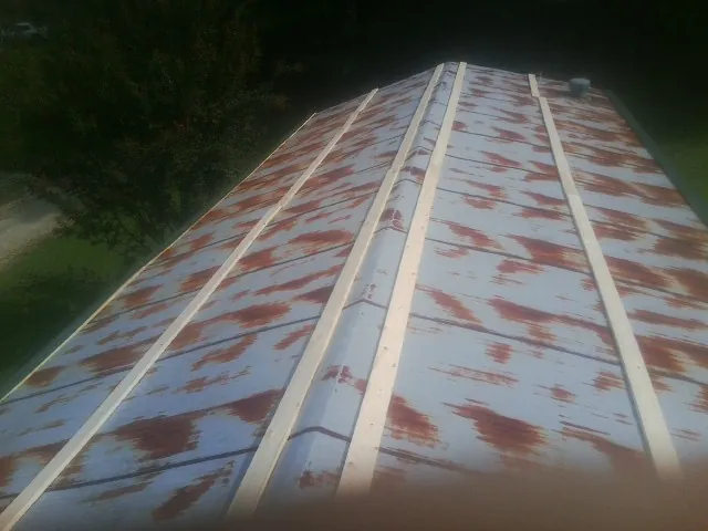 Rusted metal roof panels with new wood purlins before replacement — Storm Damage Roof Repair in Paw Paw by Roofing Brothers