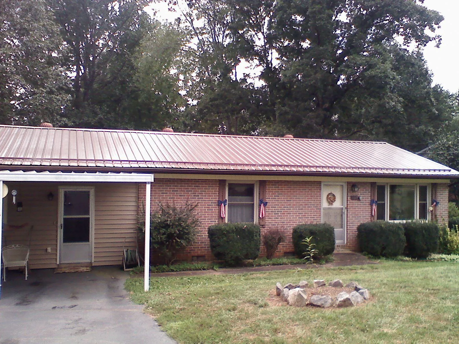 Bronze metal roof and carport on a brick ranch home — Roof Repair work by our crew in Paw Paw
